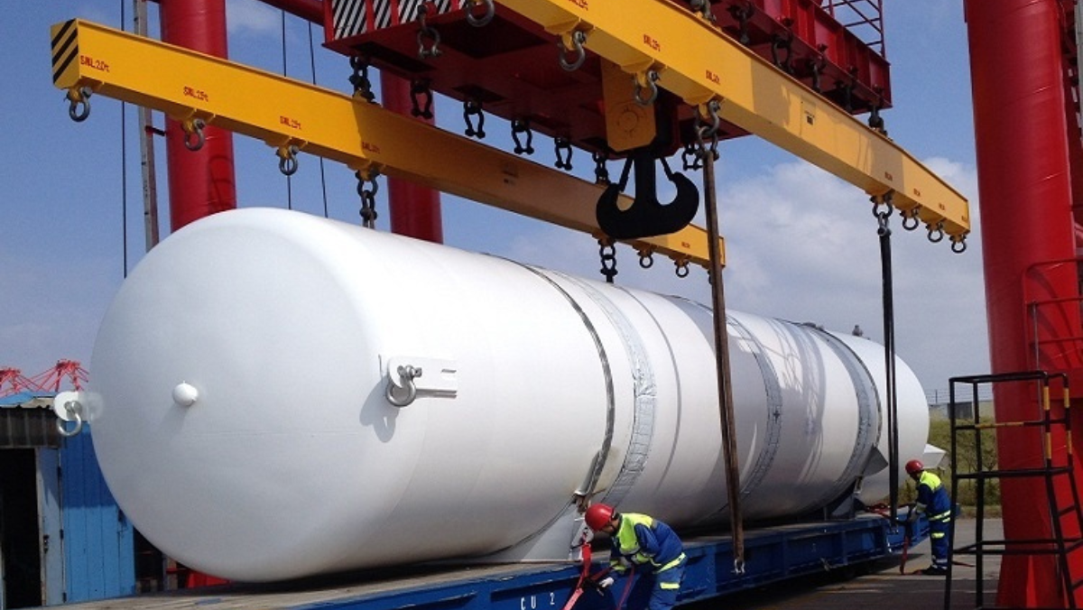 Cryogenic CO2 capture tank being installed by workers at a facility.