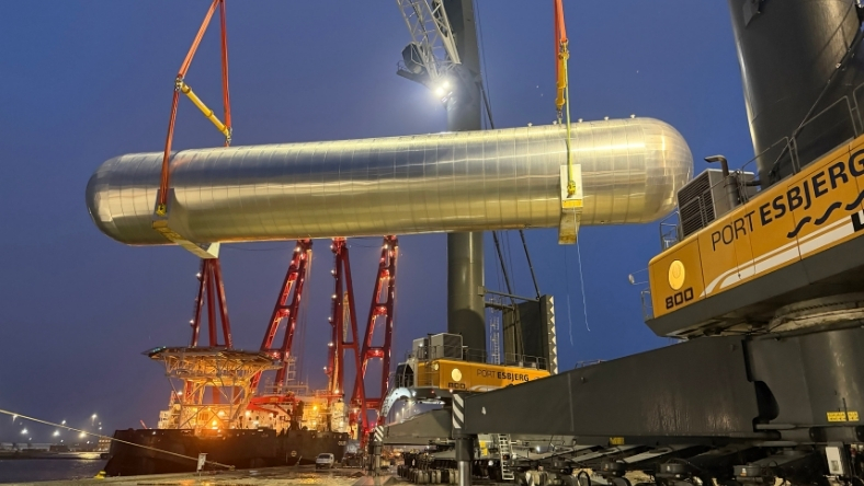 Large cylindrical CO2 storage tank lifted by crane at Port Esbjerg during installation